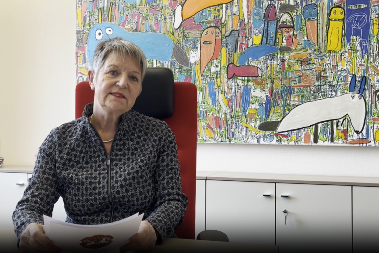 Frau sitzend auf einem Stuhl mit Redekarten