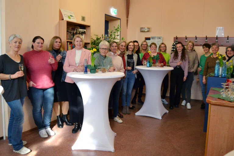 viele Frauen lächelnd an Stehtischen