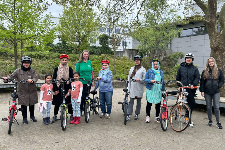 viele Frauen und Mädchen lächelnd mit Fahrrädern