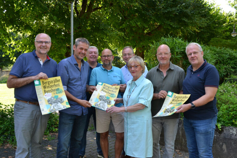 Menschen halten Flyer und Plakate zum Winzerfest in der Hand.