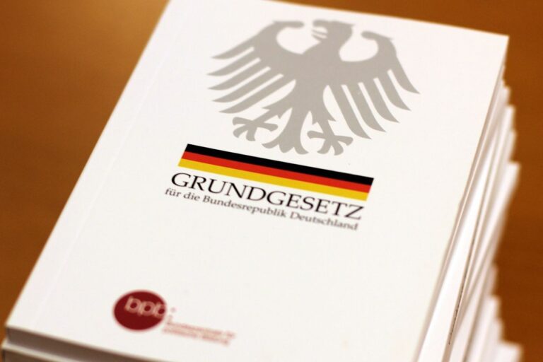 ein Buch mit dem Titel "Grundgesetz", auf dem ein Adler und eine Flagge in schwarz, rot, gold zu sehen ist