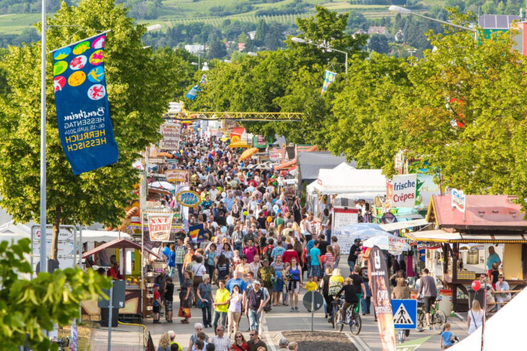 viele Personen laufen auf der Straße an Imbissständen vorbei