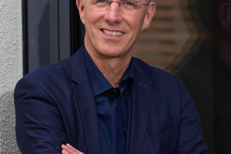 Portrait von einem Mann mit Brille und kurzen grauen Haaren