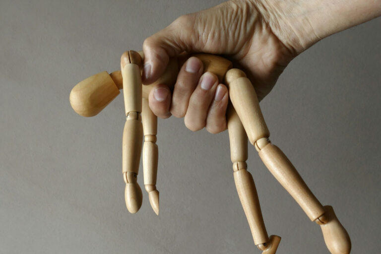 Holzfigur in einer menschlichen Hand