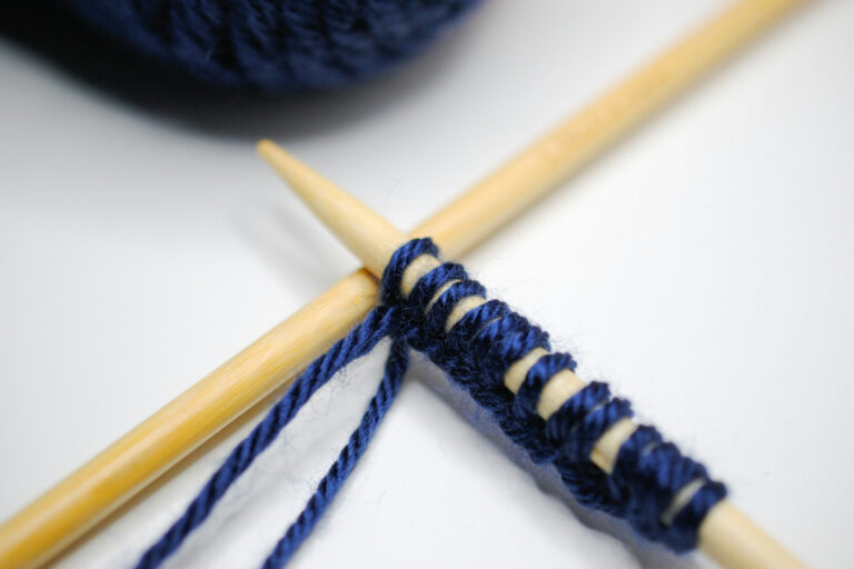 Stricknadeln mit blauer Wolle