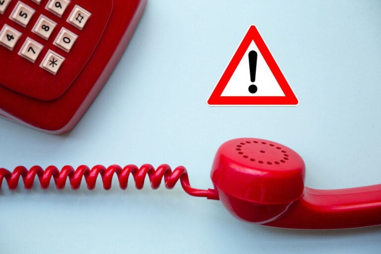 Rotes Telefon mit Warnschild