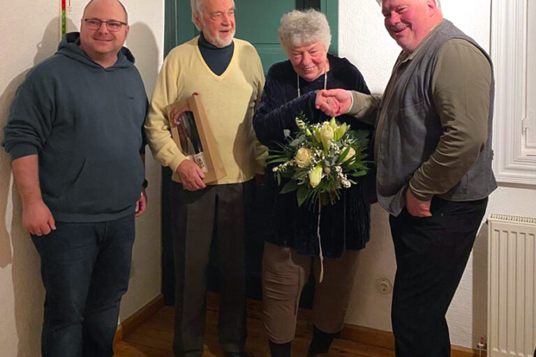 4 Personen stehend als halb Kreis und lachen
