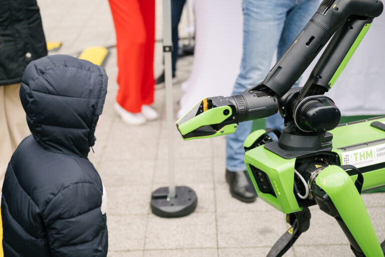 Kind betrachtet Roboter bei der KI-Tour