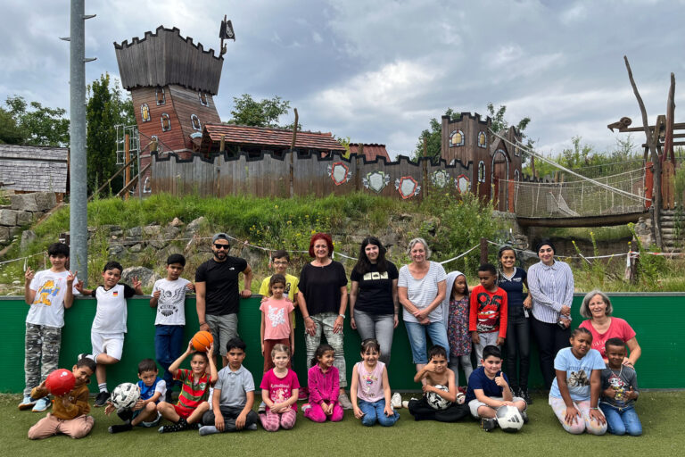 Gruppe von Erwachsenen und Kindern auf Wiese