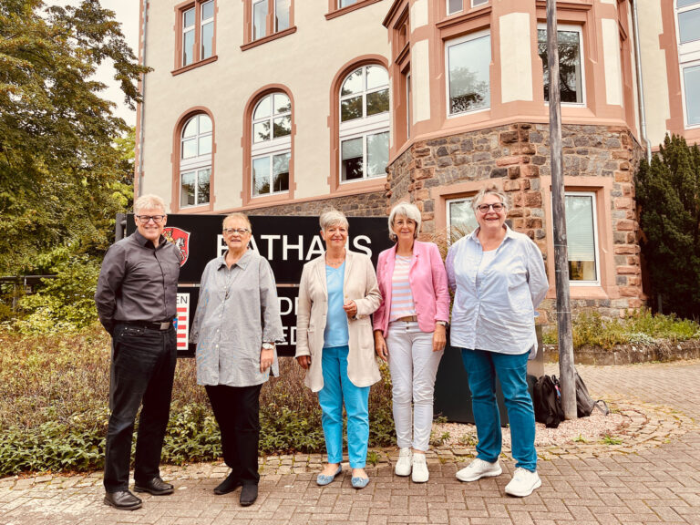 Gruppe von Menschen mit der Seniorenbeauftragten vor dem Rathaus