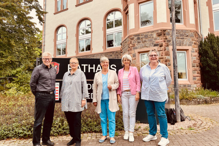 Gruppe von Menschen mit der Seniorenbeauftragten vor dem Rathaus