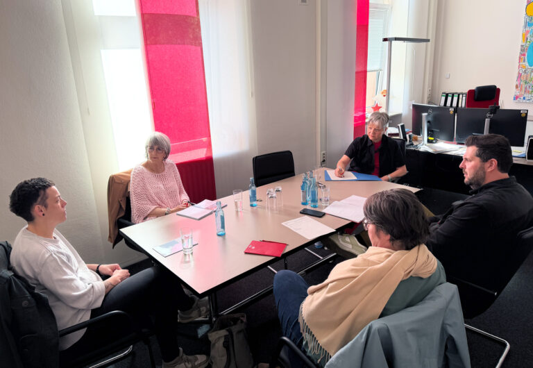 Personen sitzend an einem Tisch und unterhalten sich