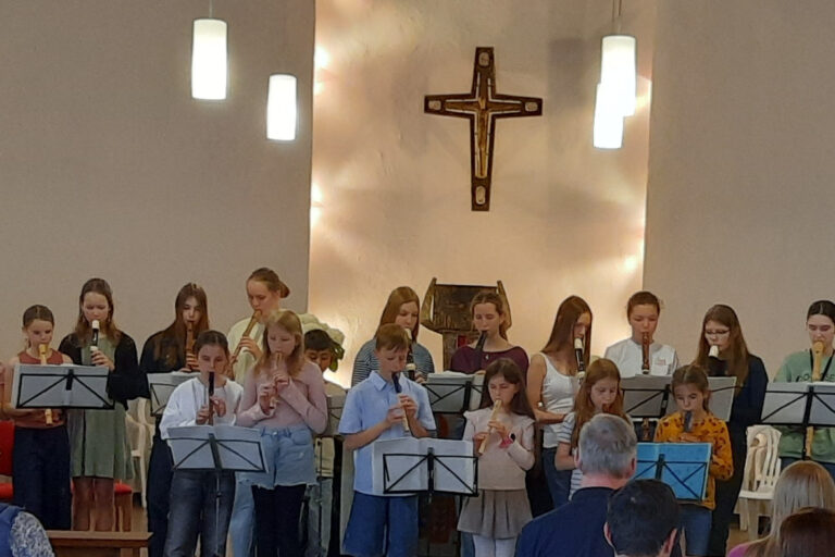 Kinder spielen auf Flöten etwas vor