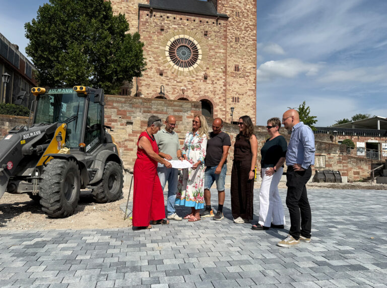 Personen stehend auf einer gepflasterten Stelle vor der St. Georg Kirche