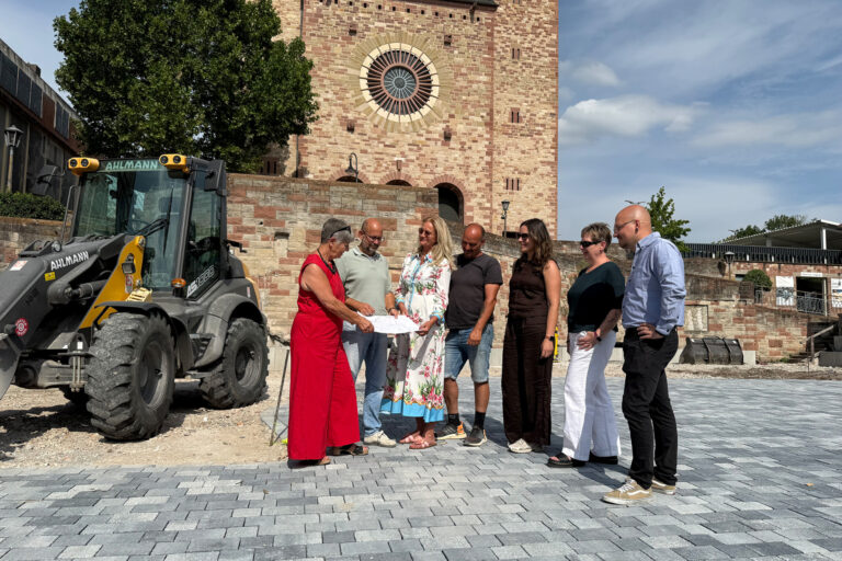 Personen stehend auf einer gepflasterten Stelle vor der St. Georg Kirche
