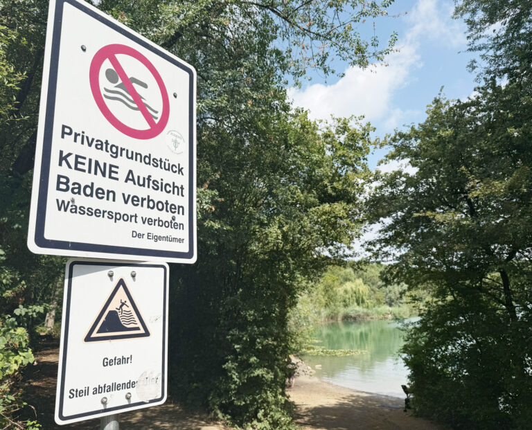 zwei Verbotsschild am Badesee