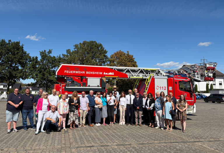 Personen stehend vor einem Feuerwehrauto