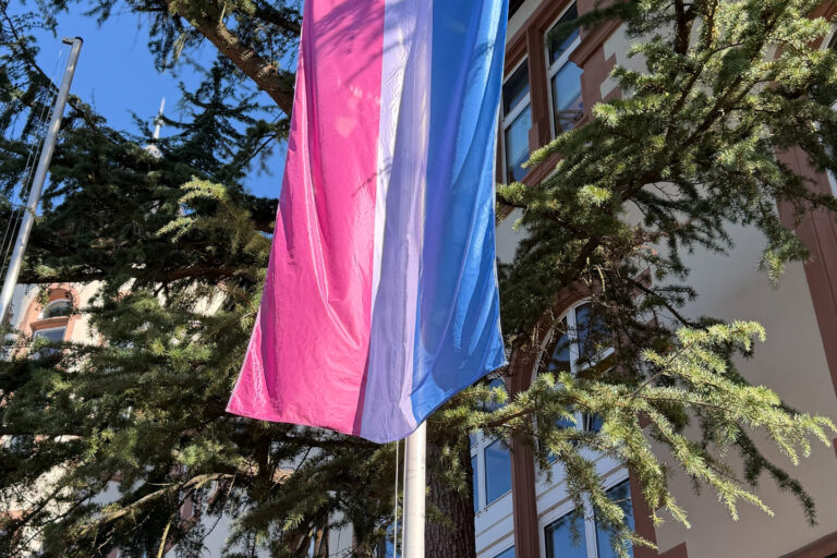 Bi Pride Flagge weht am Fahnenmast vor dem Rathaus im Wind