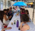 Frauen sitzend an einer langen weißen Tafel