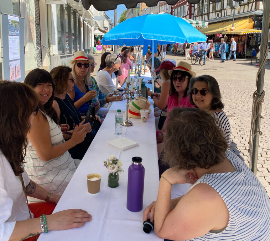 Frauen sitzend an einer langen weißen Tafel
