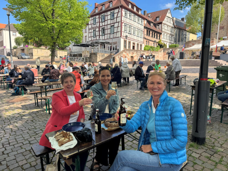 Personen sitzend an Tischen auf dem Markplatz Bensheim