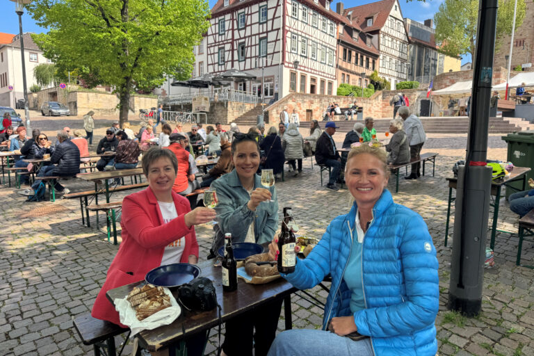 Personen sitzend an Tischen auf dem Markplatz Bensheim
