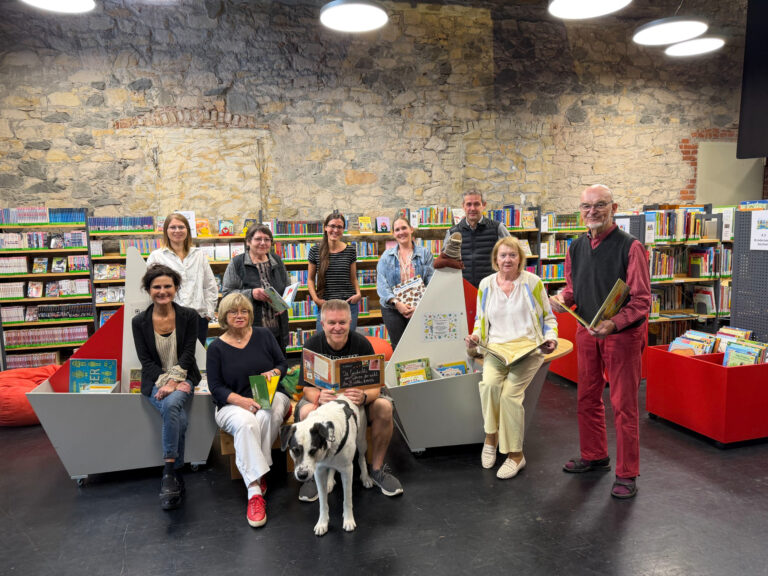 Personen sitzend und stehend mit Büchern in der Hand