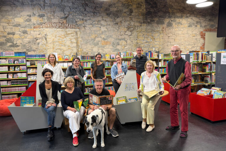 Personen sitzend und stehend mit Büchern in der Hand