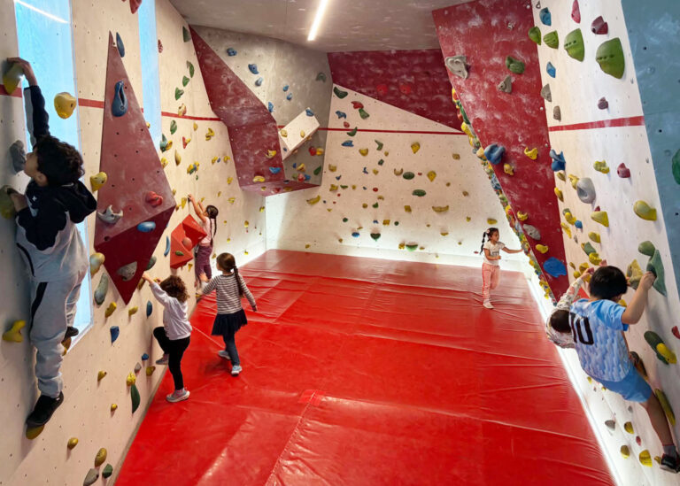 Kinder klettern an einer Kletterwand