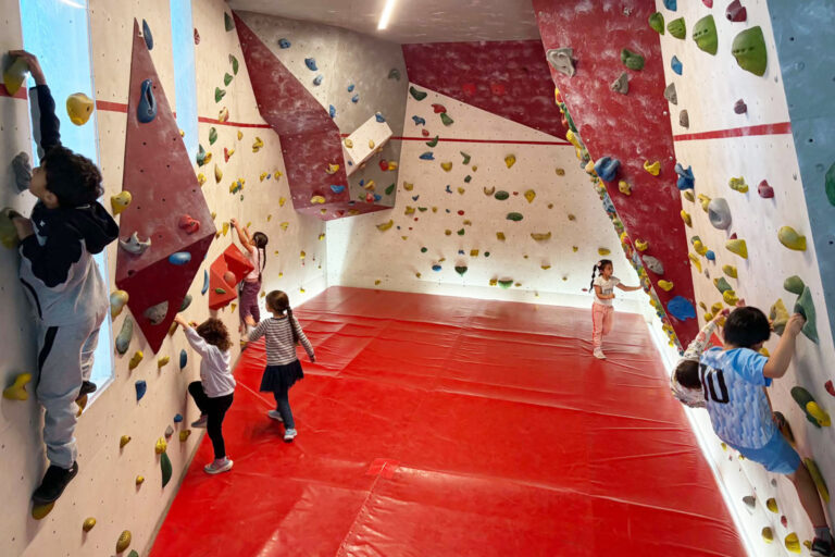 Kinder klettern an einer Kletterwand