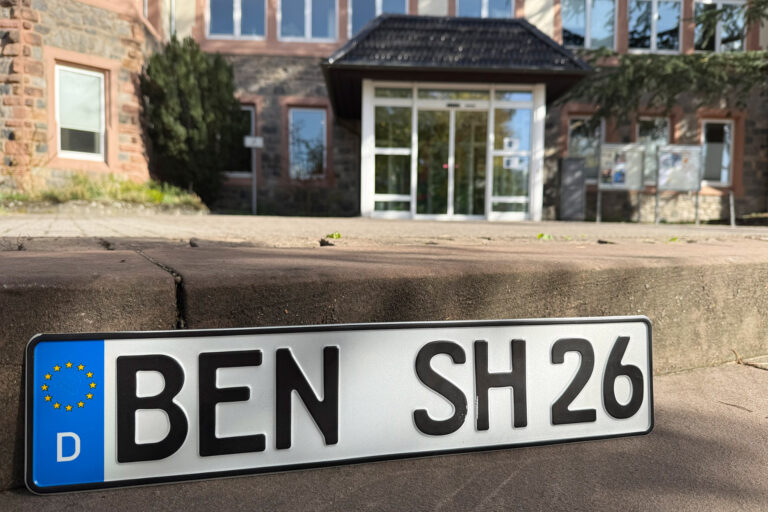 im Vordergrund das Kennzeichen mit BEN und im Hintergrund das Rathaus