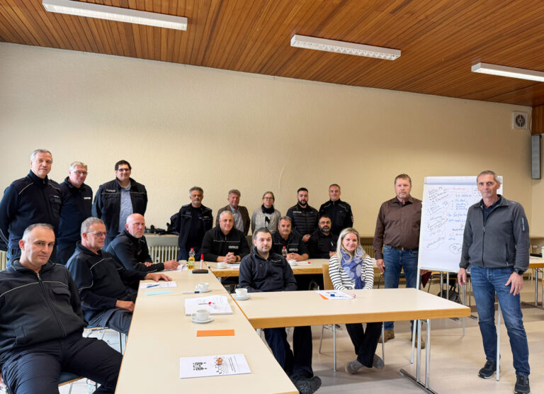 Personen sitzend und stehend an Tischen
