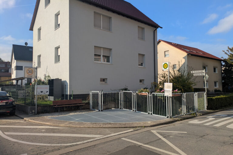 Wohngebäude und davor eine Bushaltestelle