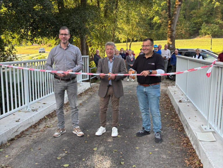 Personen stehend mit Band in der Hand und schneiden das durch