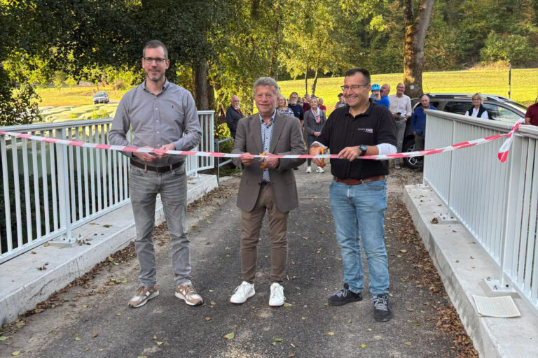 Personen stehend mit Band in der Hand und schneiden das durch